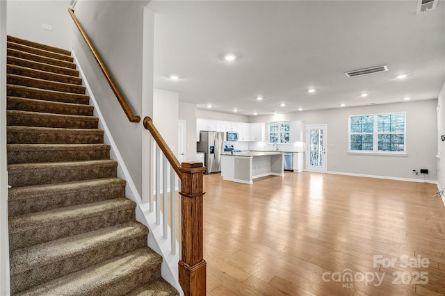 stairs with sink and hardwood / wood-style flooring