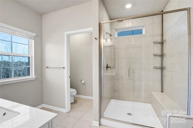 bathroom featuring a wealth of natural light, tile patterned flooring, vanity, and toilet