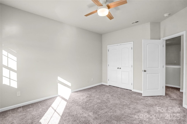 unfurnished bedroom with ceiling fan, light carpet, and a closet