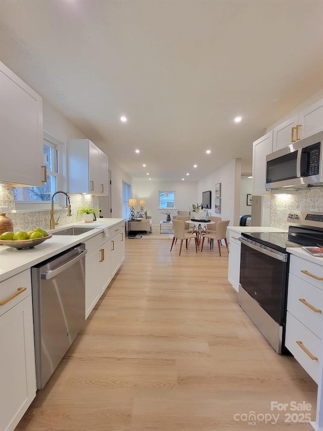 kitchen featuring white cabinetry, appliances with stainless steel finishes, and tasteful backsplash