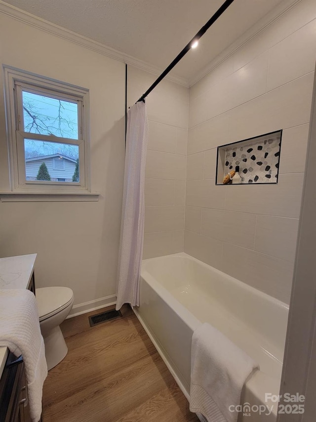 full bathroom featuring vanity, crown molding, hardwood / wood-style flooring, toilet, and shower / tub combo with curtain