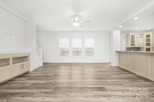 unfurnished living room featuring light hardwood / wood-style flooring and ceiling fan