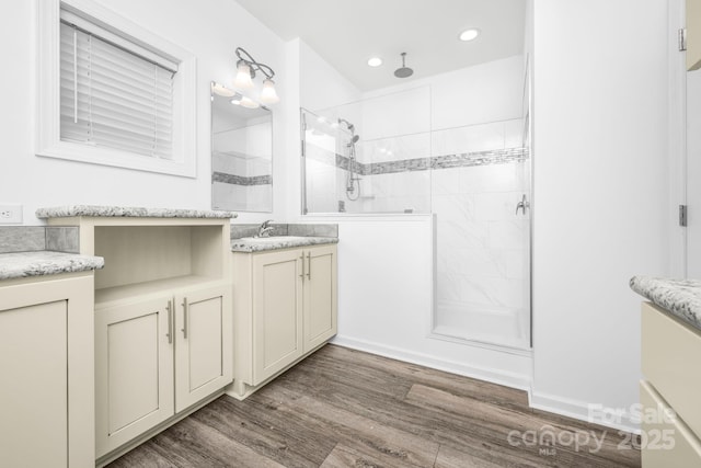 bathroom with a tile shower, vanity, and hardwood / wood-style flooring