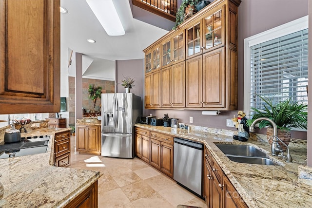 kitchen featuring light stone counters, sink, and appliances with stainless steel finishes