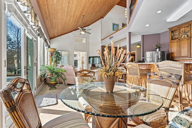 tiled dining room featuring ceiling fan, wooden ceiling, and high vaulted ceiling