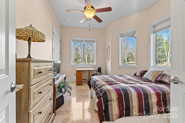 bedroom with ceiling fan, light tile patterned floors, and multiple windows