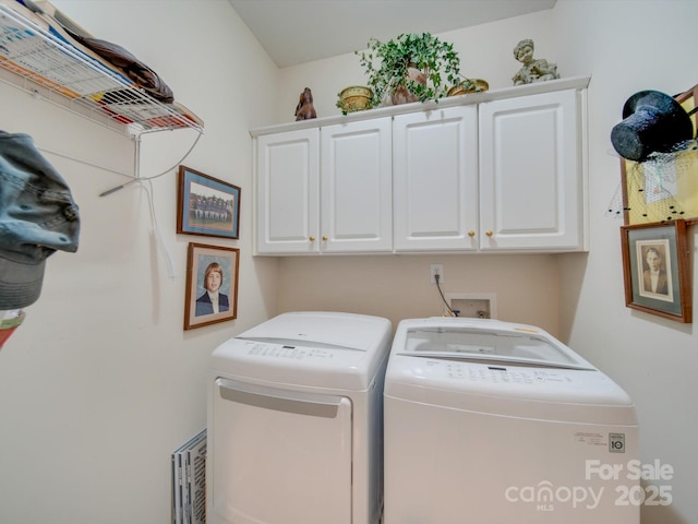 laundry room with washer and dryer and cabinets