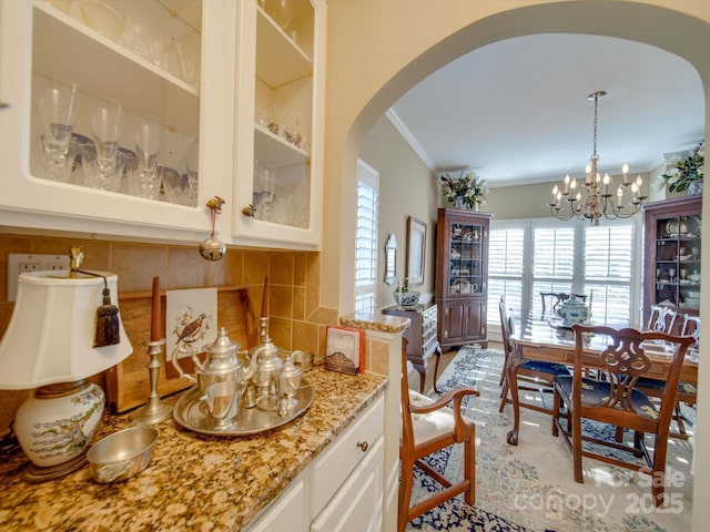 interior space with crown molding and a chandelier