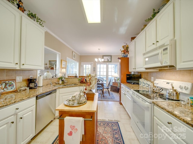 kitchen featuring pendant lighting, white appliances, white cabinets, sink, and butcher block counters