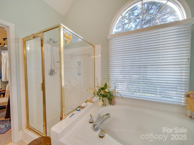 bathroom featuring a shower with door and lofted ceiling