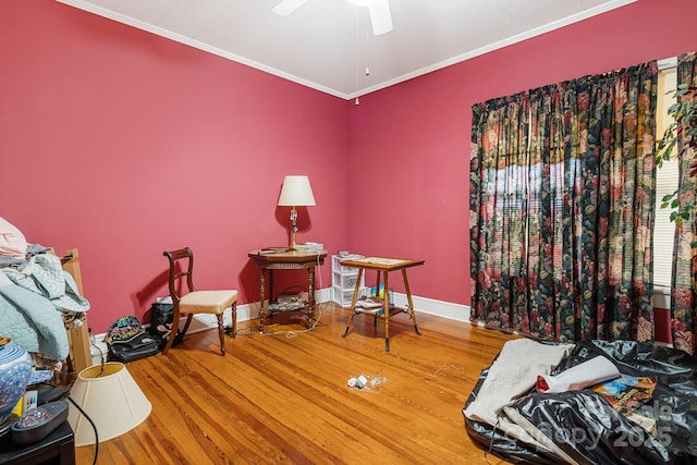 living area with hardwood / wood-style floors, ceiling fan, and crown molding