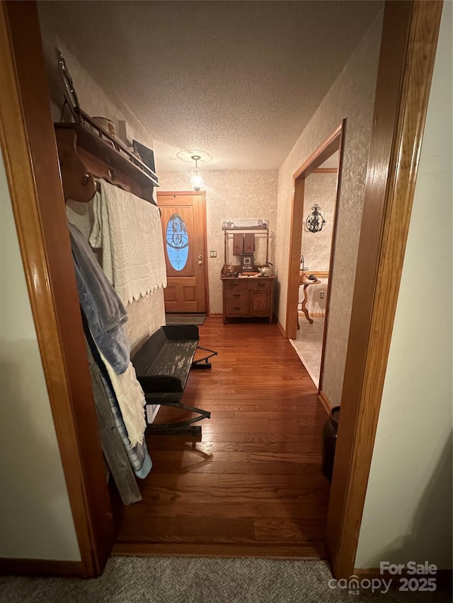 corridor featuring hardwood / wood-style flooring and a textured ceiling