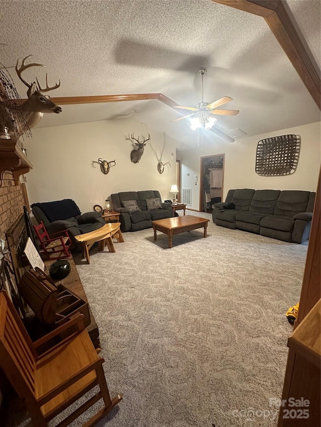 carpeted living room featuring a textured ceiling, ceiling fan, vaulted ceiling with beams, and a fireplace