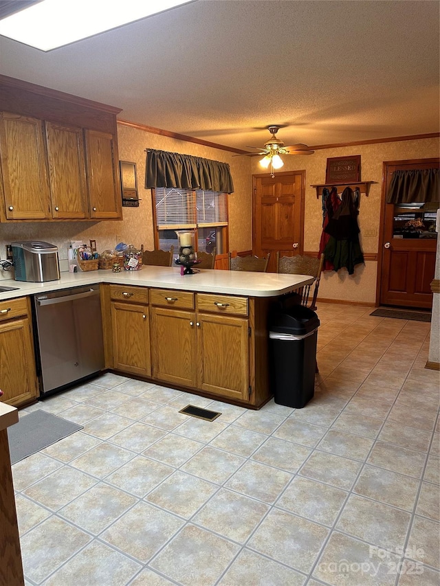 kitchen featuring kitchen peninsula, dishwasher, light tile patterned floors, crown molding, and ceiling fan