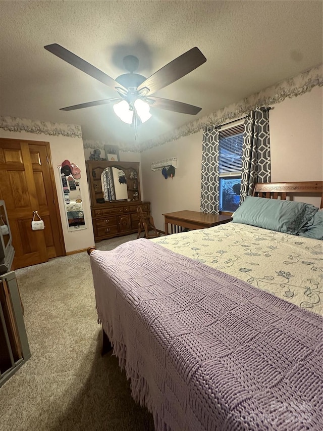 carpeted bedroom featuring a textured ceiling and ceiling fan