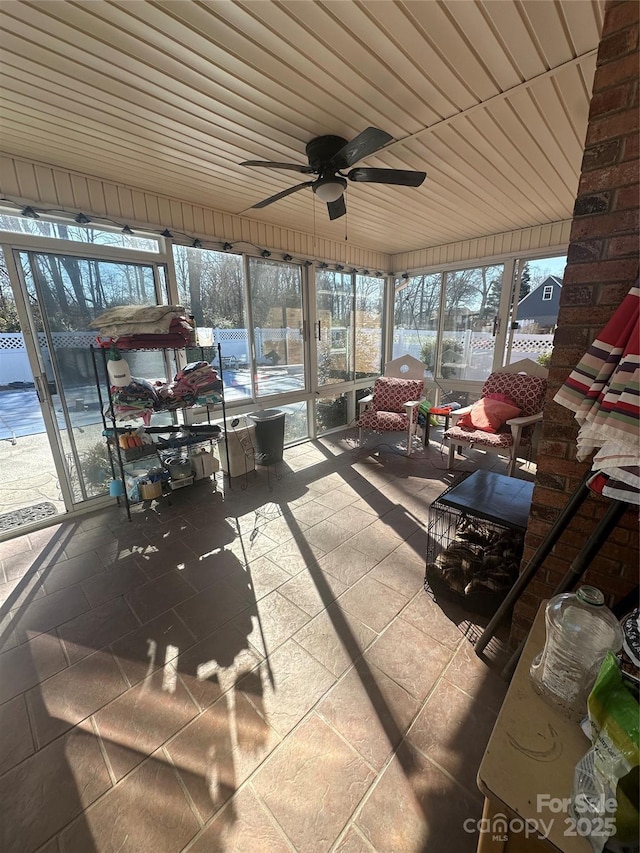 sunroom with ceiling fan and wooden ceiling