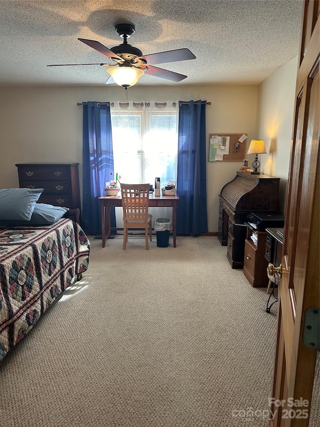 carpeted bedroom with ceiling fan and a textured ceiling