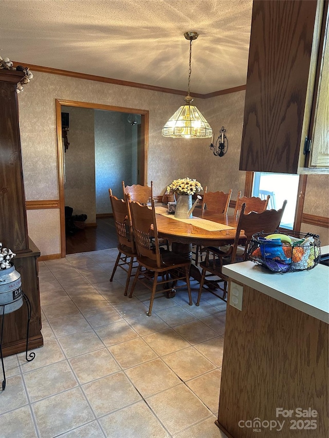 tiled dining area featuring a textured ceiling and crown molding