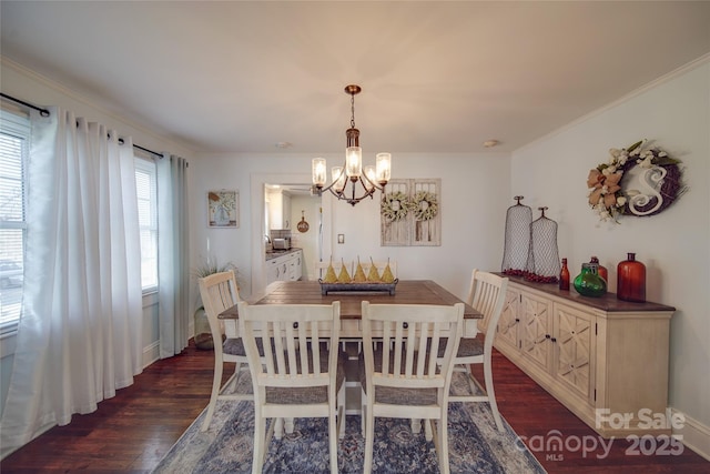 dining space with ornamental molding, dark wood-type flooring, and an inviting chandelier