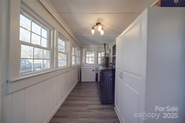 clothes washing area with separate washer and dryer, dark hardwood / wood-style flooring, cabinets, and ornamental molding