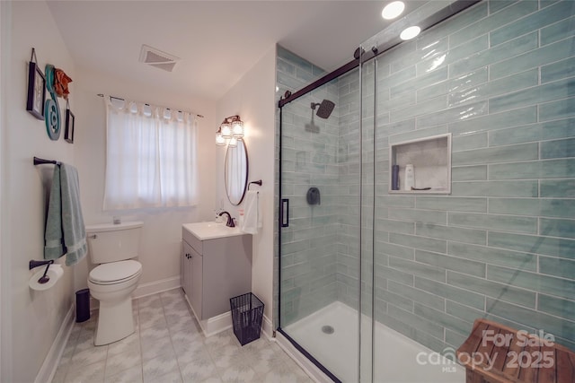 bathroom featuring tile patterned floors, vanity, toilet, and walk in shower