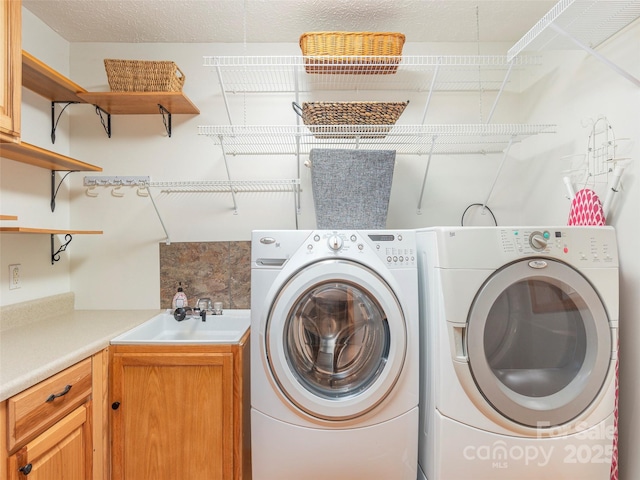 washroom with washer and dryer, cabinets, and sink