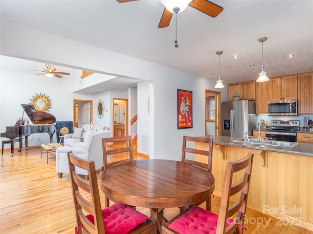 1185 Mule Stomp Rd, Clyde, NC 28721 - dining room featuring a ceiling fan, light wood-style floors, and stairway