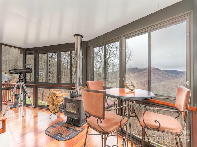 sunroom with a mountain view and a wood stove