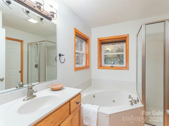 bathroom featuring a textured ceiling, vanity, and independent shower and bath