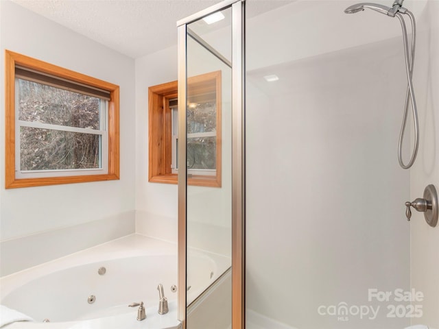 bathroom with a textured ceiling and shower with separate bathtub