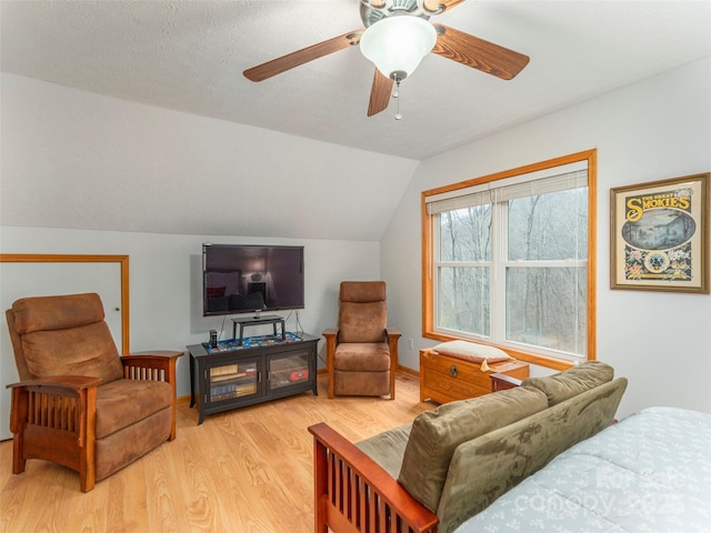 living room with hardwood / wood-style flooring, ceiling fan, a textured ceiling, and vaulted ceiling