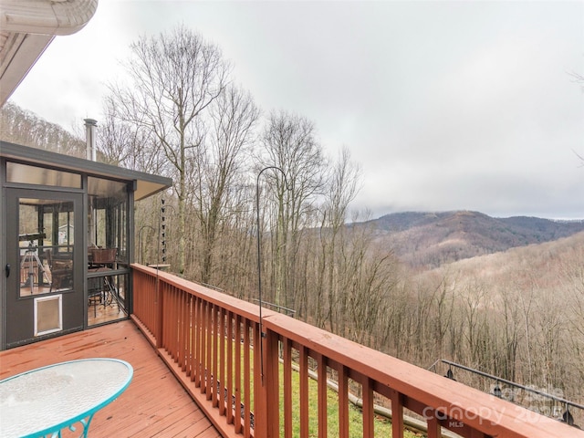 wooden terrace featuring a sunroom and a mountain view