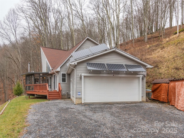 view of front of property featuring a sunroom, solar panels, and a deck