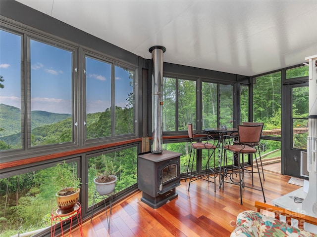 1185 Mule Stomp Rd, Clyde, NC 28721 - sunroom with a wood stove, wood finished floors, and a deck