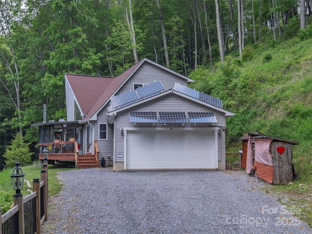 1185 Mule Stomp Rd, Clyde, NC 28721 - view of front of house with roof mounted solar panels, a view of trees, a wooden deck, and a garage