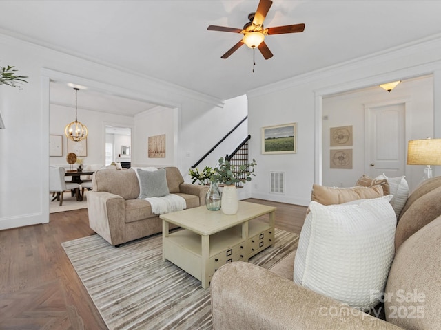 living room with ceiling fan and ornamental molding