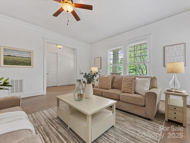 living room featuring ceiling fan, light wood-type flooring, and ornamental molding