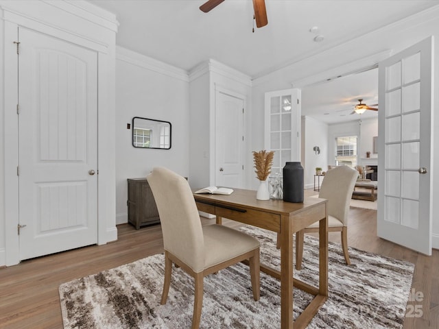 dining space featuring crown molding, light hardwood / wood-style flooring, and french doors