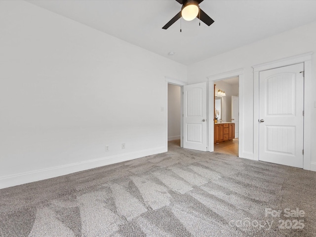 unfurnished bedroom featuring connected bathroom, light colored carpet, and ceiling fan