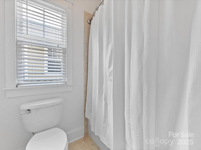 bathroom with walk in shower, a wealth of natural light, tile patterned flooring, and toilet