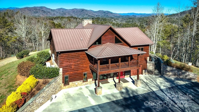 rear view of property featuring a mountain view and a patio