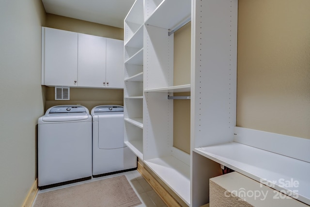 laundry area featuring washing machine and dryer and cabinets