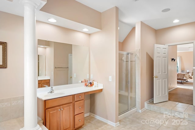 bathroom with tile patterned flooring, a shower with shower door, and decorative columns