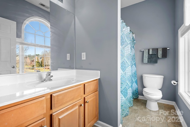 bathroom with toilet, vanity, and tile patterned floors