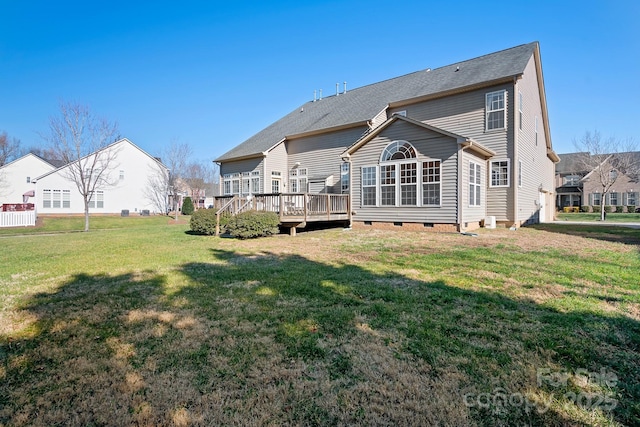 rear view of property with a yard and a wooden deck