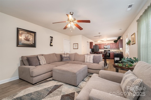 living room featuring ceiling fan and light wood-type flooring