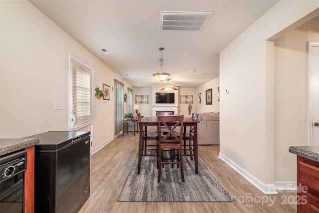 dining space with hardwood / wood-style floors and ceiling fan