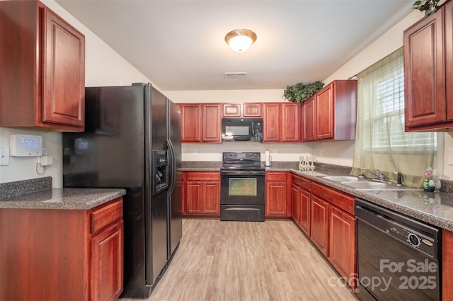 kitchen with black appliances, light wood-type flooring, and sink