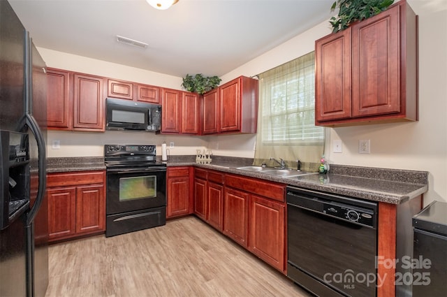 kitchen with black appliances, light hardwood / wood-style floors, and sink