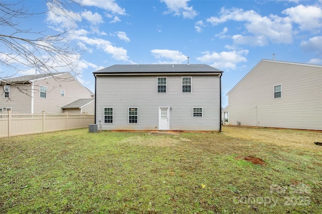 rear view of property with a lawn and central AC